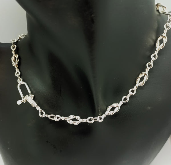 Reef knots linked together into a fine chain, with a silver shackle and hook clasp